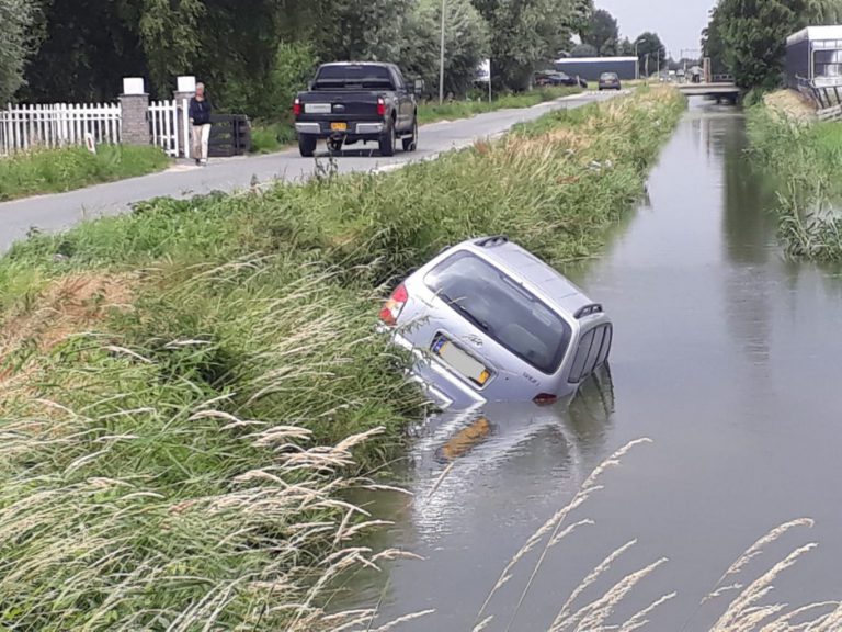 Auto te water langs Zuidplasweg in Nieuwerkerk